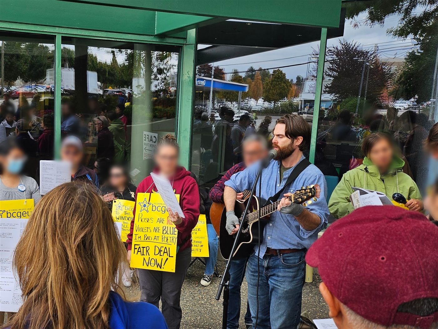 Laurence singing and playing guitar for picketers during the 2025 BCGEU strike
